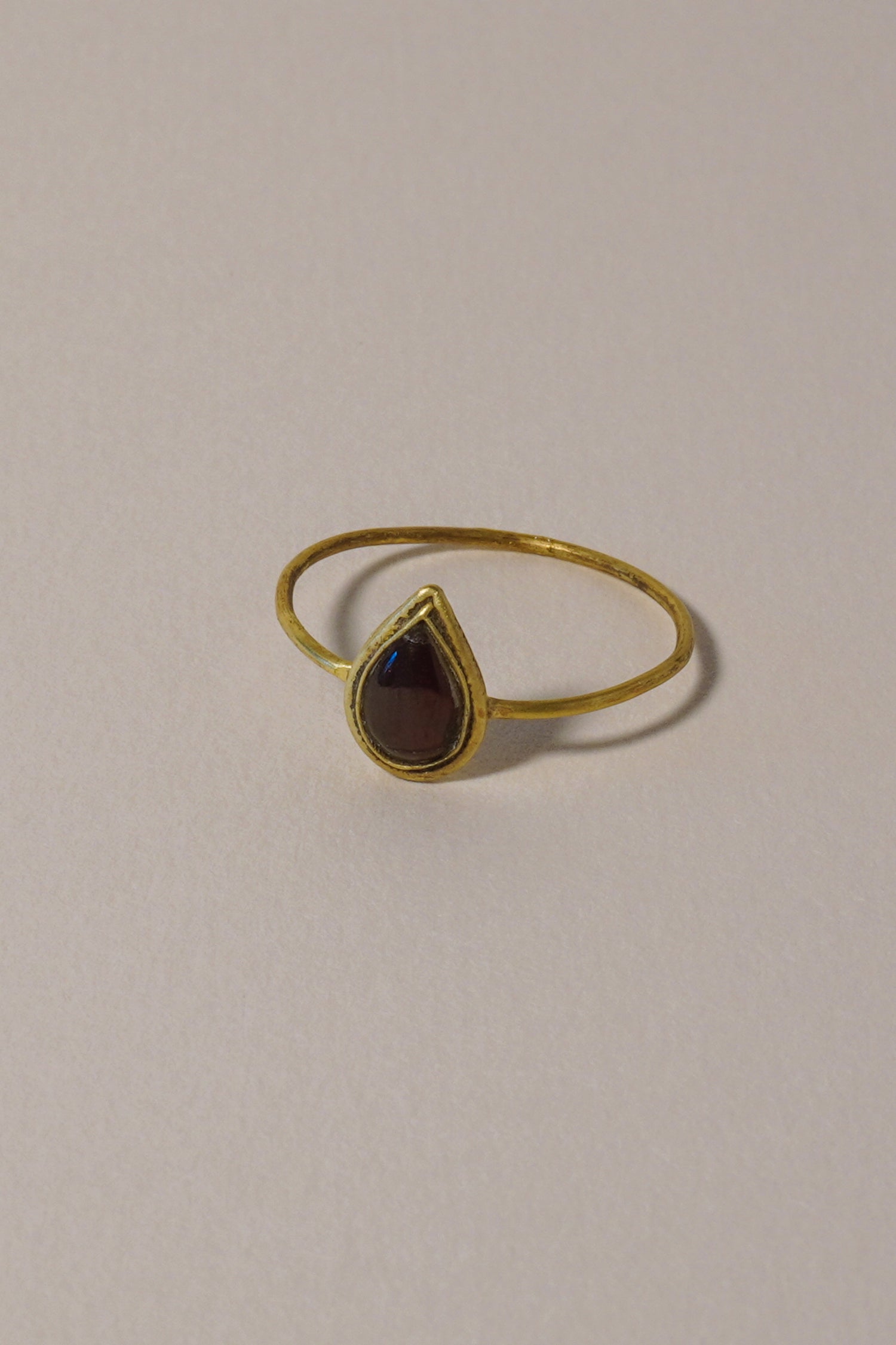 MEDIEVAL GOLD RING WITH GARNET CABOCHON, PEAR-SHAPED BEZEL. 14TH-16TH CENTURY AD