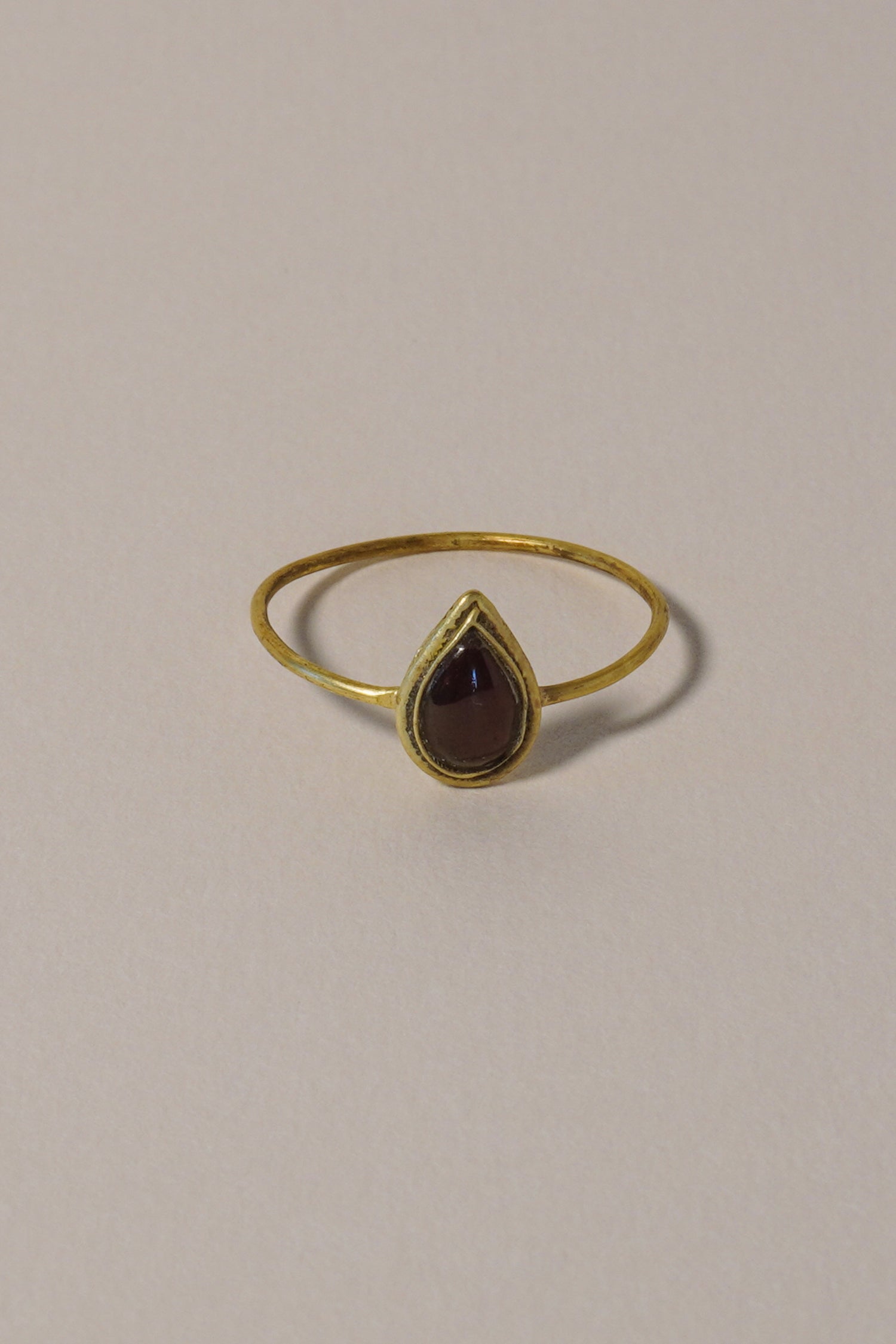 MEDIEVAL GOLD RING WITH GARNET CABOCHON, PEAR-SHAPED BEZEL. 14TH-16TH CENTURY AD FRONT