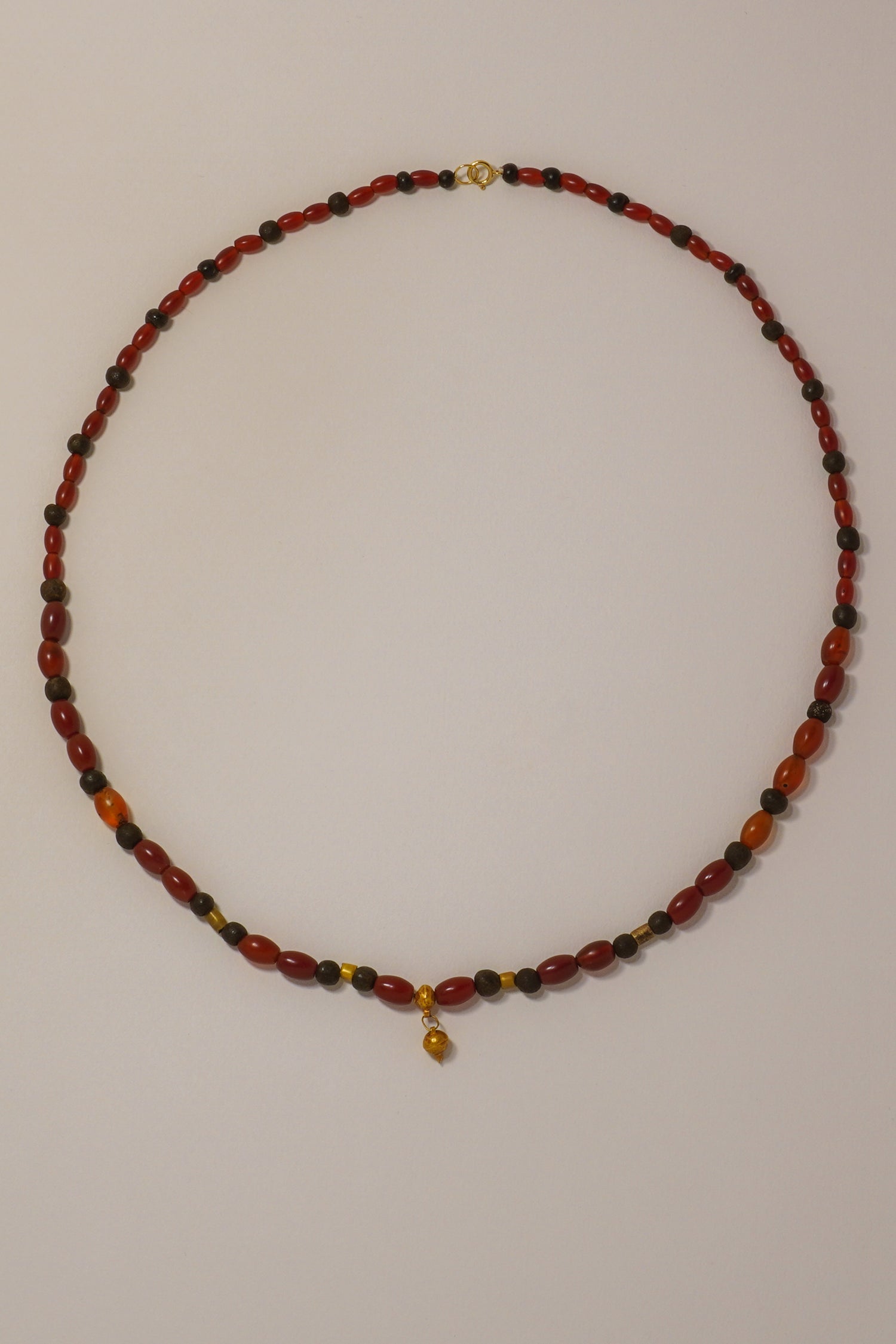 ANCIENT GREEK GOLD AND CARNELIAN BEADED NECKLACE WITH POMEGRANATE AMULET. 6TH-3RD CENTURY BC